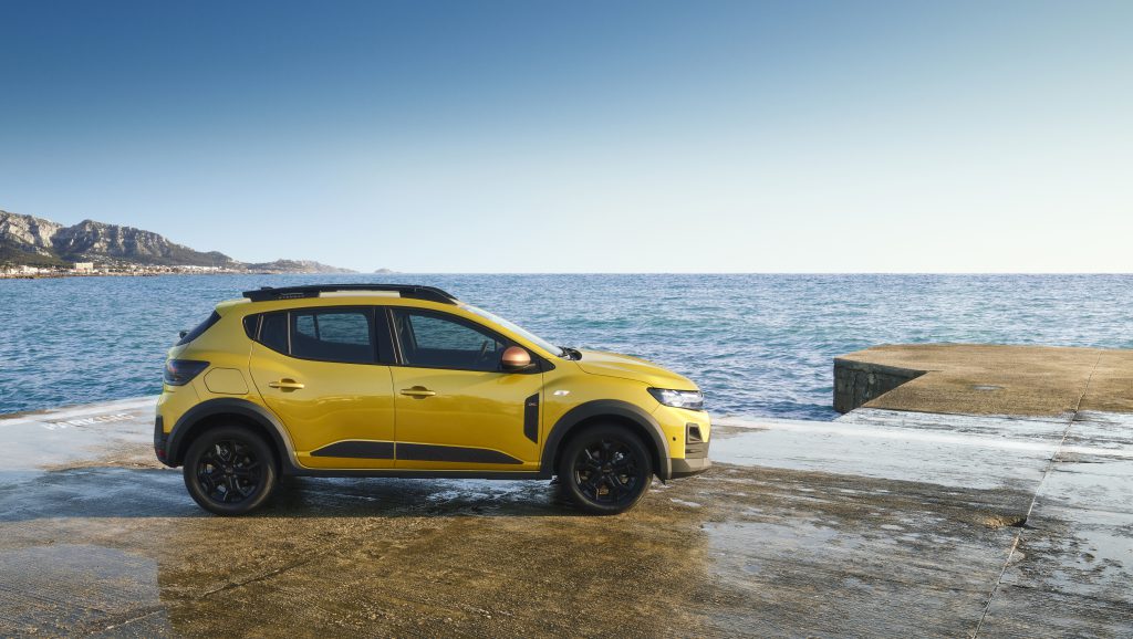 Dacia Sandero Stepway u žutoj boji, bočni profil, parkiran pored mora