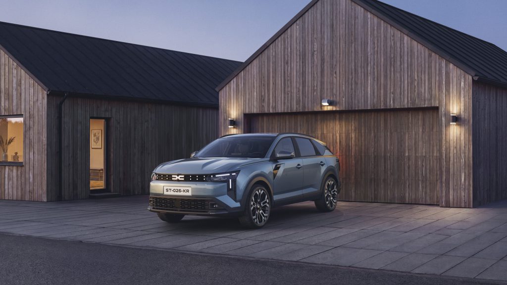 Dacia Striker iz prednjeg ugla ispred drvene kuće, boja Frost Green