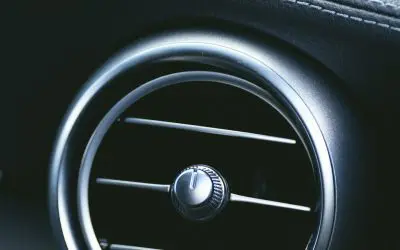 Krupni plan okruglog ventilacionog otvora klime na tabli automobila