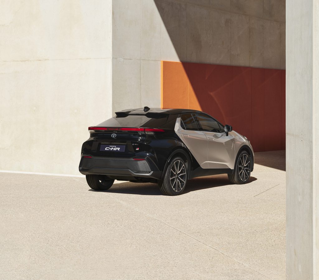 Toyota C-HR druge generacije, pogled sa zadnjeg ugla sa osvetljenim zadnjim svetlima