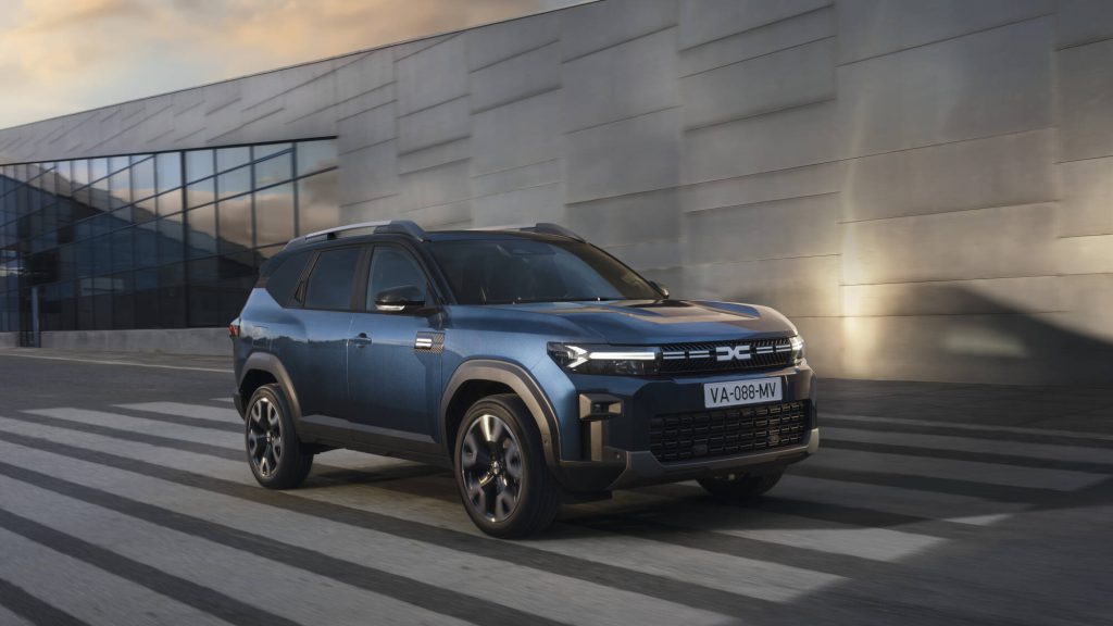 Dacia Bigster snimljen iz prednjeg 3/4 ugla ispred betonske fasade