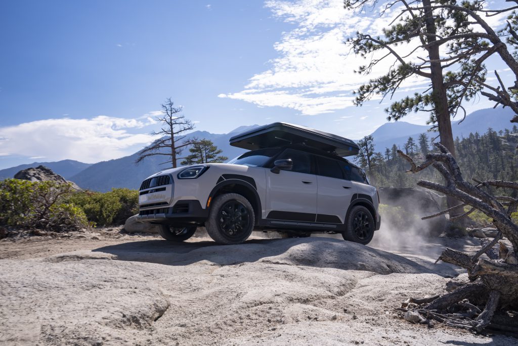 MINI Countryman u vožnji po prašnjavom šumskom putu sa krovnim šatorom