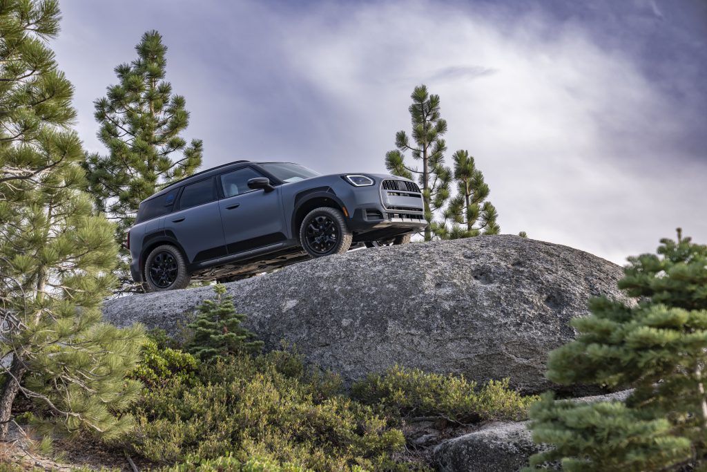 MINI Countryman u profilu dok se penje preko velike stene u planini