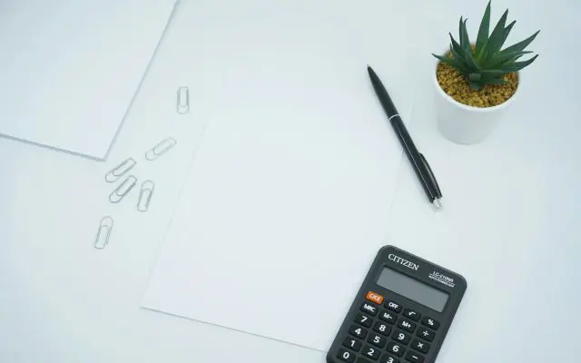 Kalkulator, olovka i prazan list papira na stolu, kao ilustracija izračunavanja rate kredita ili lizinga