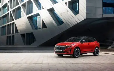Nissan Qashqai e-Power u crvenoj boji, pogled spreda i sa strane, urbano okruženje
