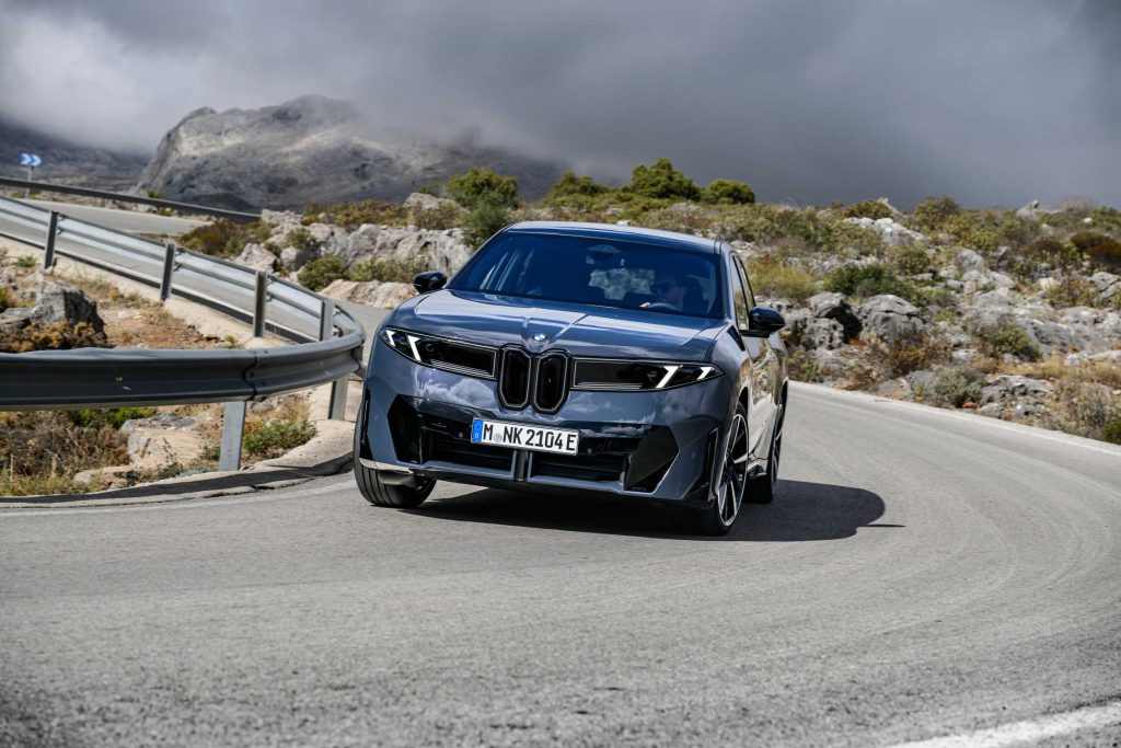 BMW iX3 50 xDrive u voznji, pogled gotovo direktno spreda na planinskom putu