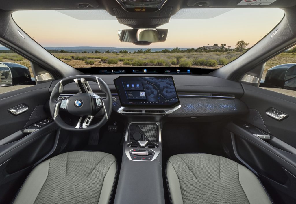 Enterijer BMW iX4 sa panoramskim ekranom, volanom i prednjim sedistima