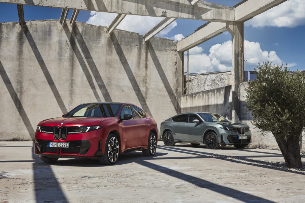 BMW iX4 u dve izvedbe, crvena M60 xDrive i zelena 50 xDrive, parkirane jedna pored druge