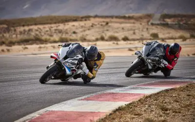 BMW S 1000 RR u nagibu kroz krivinu na stazi, dva motocikla jedan iza drugog
