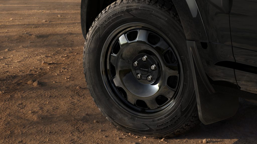 Detalj crnog aluminijumskog točka i terenske gume Land Rover Defendera