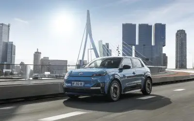 Nissan Micra EV u vožnji pored mosta Erasmus u Roterdamu, pogled iz prednjeg ugla