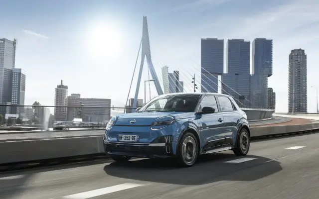 Nissan Micra EV u vožnji pored mosta Erasmus u Roterdamu, pogled iz prednjeg ugla