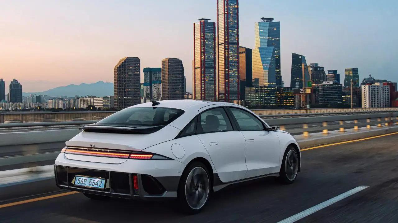 Hyundai Ioniq 6, zadnji ugao u vožnji na auto-putu, siluetom grada Seula u pozadini