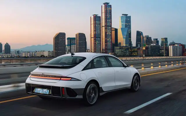 Hyundai Ioniq 6, zadnji ugao u vožnji na auto-putu, siluetom grada Seula u pozadini