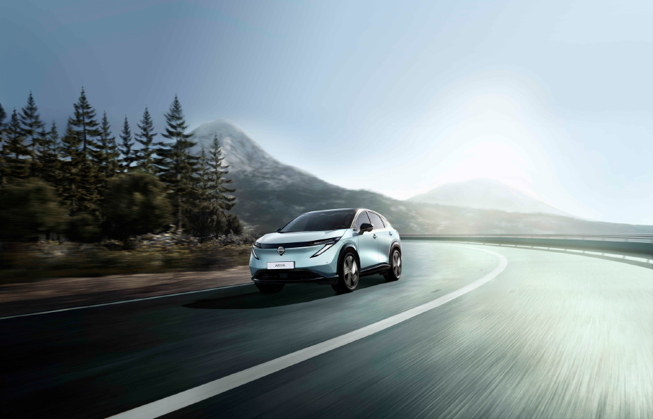 Nissan Ariya (fejslift 2026), prednji ugao u vožnji planinskim putem pored šume