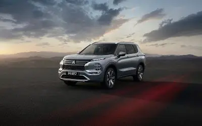 Mitsubishi Outlander PHEV, srebrna boja, pogled spreda sa strane u sumrak