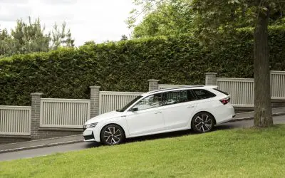 Bočni profil Škoda Octavia Combi u beloj boji, parkiran pored ograde