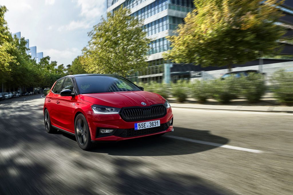 Crvena Škoda Fabia Monte Carlo u vožnji gradskom ulicom, snimljena iz prednjeg tročetvrtinskog ugla