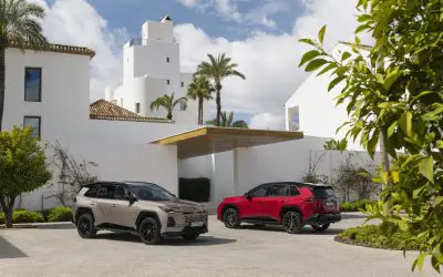 Toyota RAV4 šesta generacija, plug-in hibrid, dva vozila (bež i crvena), prednji i zadnji ugao parkirana ispred vile