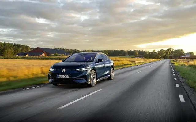 Volkswagen ID.7 Pro S, tamnoplava limuzina/liftback u vožnji, prednji 3/4 ugao